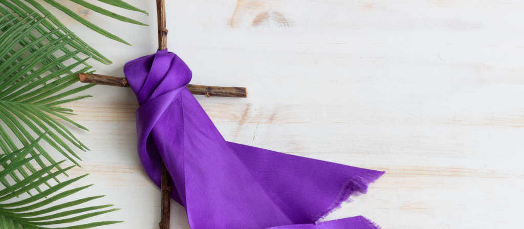 Photo d'une croix en voix, un tissu violet et une branche de rameau