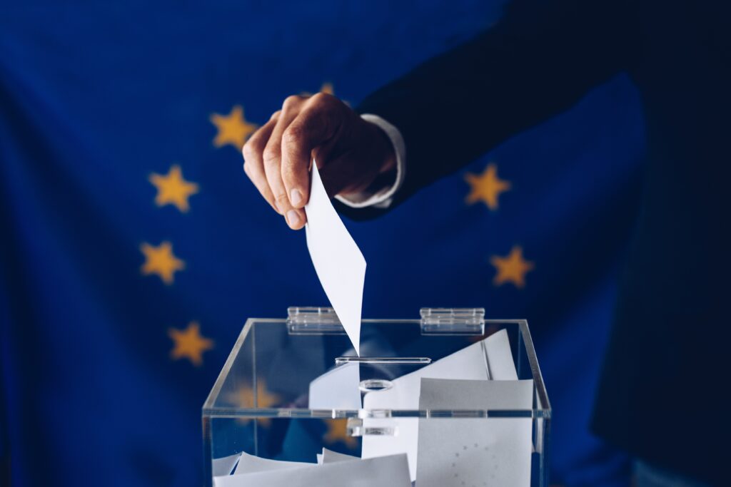 Hommes mettant un bulletin de vote dans une urne à l'occasion des élections européennes.